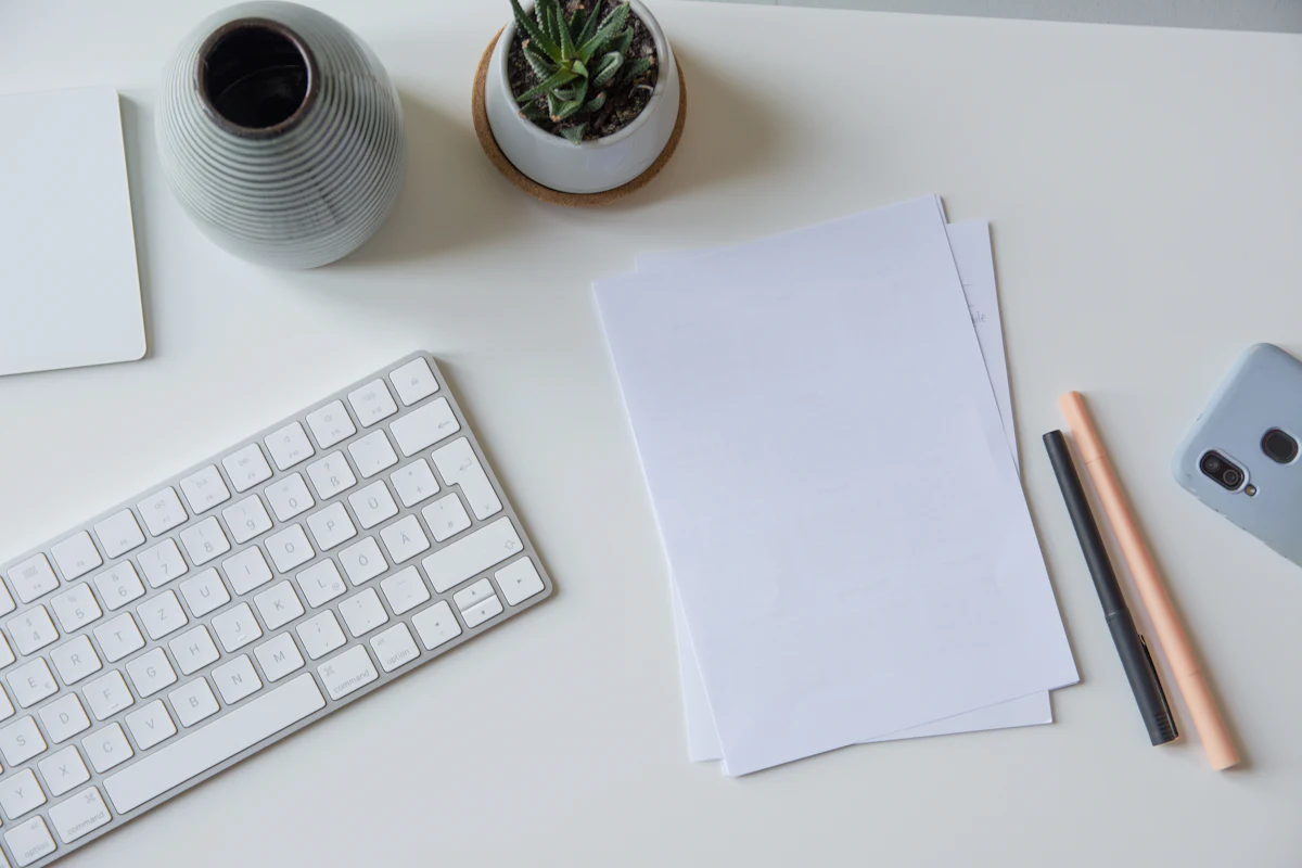 Heller Schreibtisch mit Tastatur, Papier und Stiften